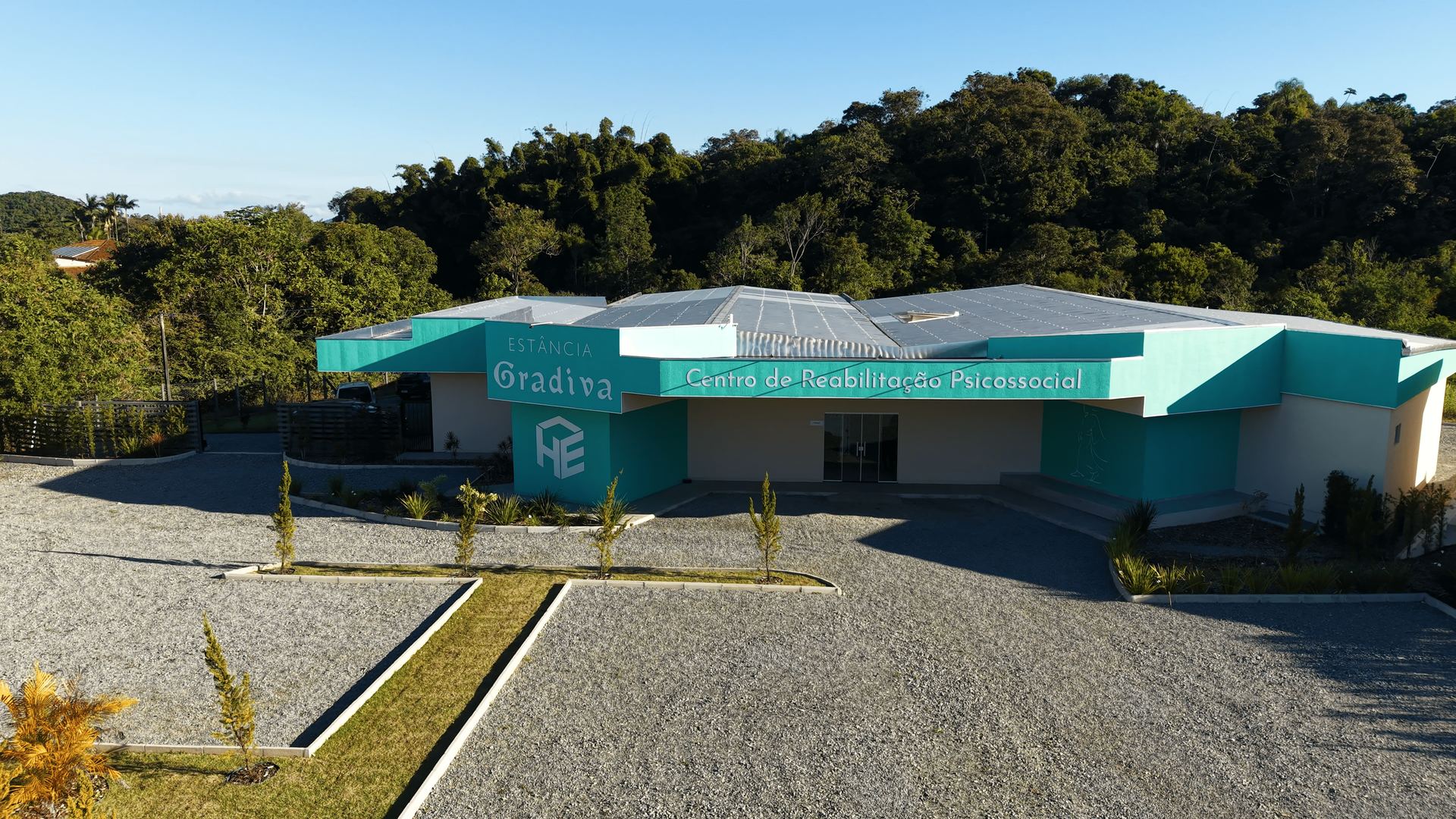 Fachada e recepção da Estância Gradiva Araquari, com paisagismo e entrada arejada
